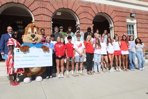 First Commerce Credit Union leaders and Sammy Squirrel, the First Commerce mascot, present Leon High School with a $1,000 gift to beautify the campus with trees.
